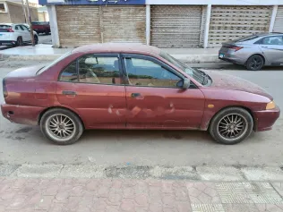 ميتسوبيشي ميراج 1999 أحمر غامق مستعملة للبيع